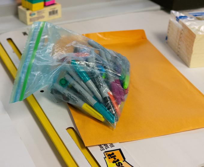 Photograph of sharpies, folders, and notebooks at a conference