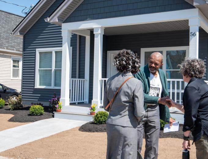 Photo of people outside a house.