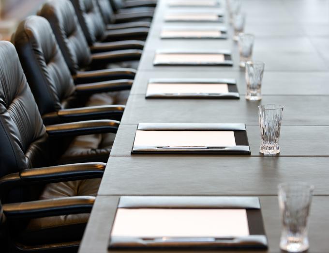 Photo of empty office chairs in a conference room.
