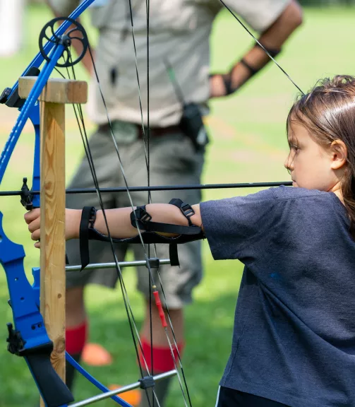 Photo of a girl shooting a bow and arrow.
